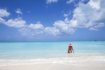 A bather with a pink hat in the turquoise waters of the Caribbean Sea, The Nest, Antigua, Antigua and Barbuda, Leeward Islands, West Indies, Caribbean, Central America