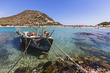 A fishing boat in the turquoise sea surrounding the sandy beach, Punta Molentis, Villasimius, Cagliari, Sardinia, Italy, Mediterranean, Europe