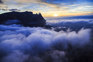 The unmistakable profile of the Sciliar Massif in the Dolomites emerging from the fog, South Tyrol, Italy, Europe