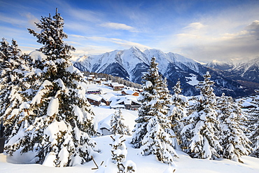 Snowy woods and mountain huts framed by the winter sunset, Bettmeralp, district of Raron, canton of Valais, Switzerland, Europe