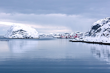 Cold sea and snowy peaks frame the fishing village at dusk, Nusfjord, Nordland, Lofoten Islands, Northern Norway, Scandinavia, Europe