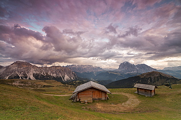 Pink clouds at sunset on the typical huts of Odle mountain range seen from Seceda, Val Gardena, Trentino-Alto Adige, Italy, Europe