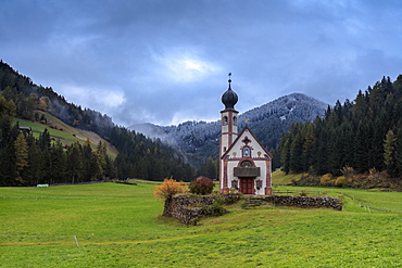 Clouds on Church of Ranui surrounded by meadows and woods in the fall, St. Magdalena, Funes Valley, South Tyrol, Dolomites, Italy, Europe