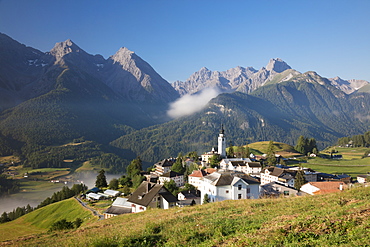 Green meadows frame the the alpine village of Ftan, Inn district, Canton of Graubunden, Engadine, Switzerland, Europe