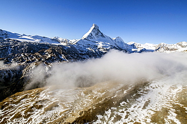 The unique shape of the Matterhorn sorrounded by its mountain range covered in snow, Swiss Canton of Valais, Swiss Alps, Switzerland, Europe