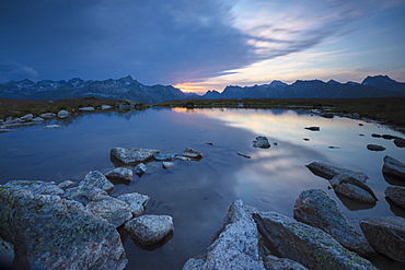 The lights of sunrise reflected in the alpine lake, Muottas Muragl, Samedan, Canton of Graubunden, Engadine, Switzerland, Europe