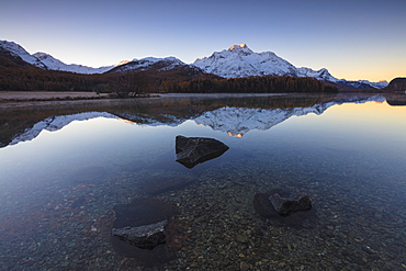 The snowy peaks are reflected in Lake Champfer at sunrise, St. Moritz, Canton of Graubunden, Engadine, Switzerland, Europe