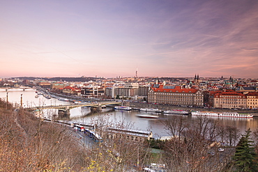 Pink sky on historical bridges and buildings reflected on Vltava River at sunset, Prague, Czech Republic, Europe