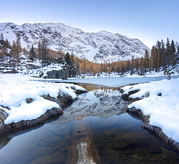 The snowy peaks reflected in the frozen Lake Mufule, Malenco Valley, Province of Sondrio, Valtellina, Lombardy, Italy, Europe