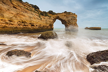 Waves crashing on the sand beach surrounded by cliffs, Albandeira, Lagoa Municipality, Algarve, Portugal, Europe