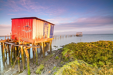 Pink sky at dawn on the Palafito Pier in the Carrasqueira Natural Reserve of Sado River, Alcacer do Sal, Setubal, Portugal, Europe