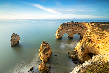 Sunrise on cliffs framed by turquoise water of the ocean, Praia da Marinha, Caramujeira, Lagoa Municipality, Algarve, Portugal, Europe