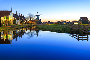 Blue lights at dusk on wooden houses and windmills of the typical village of Zaanse Schans, North Holland, The Netherlands, Europe