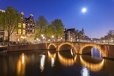 Dusk light on typical buildings and bridges reflected in a typical canal, Amsterdam, Holland (The Netherlands), Europe