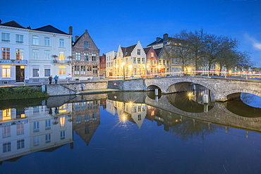 Dusk lights on the historic buildings of the city centre reflected in typical canals, Bruges, West Flanders, Belgium, Europe