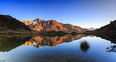 Panorama of the rocky peaks of Mount Disgrazia reflected in Lake Zana at dawn, Malenco Valley, Valtellina, Lombardy, Italy, Europe