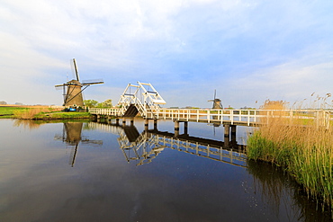 Traditional windmills and bridge on the canal framed by sunrise, Kinderdijk, UNESCO World Heritage Site, Molenwaard, South Holland, The Netherlands, Europe