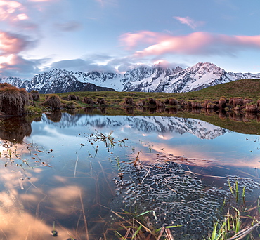 Panorama of pink clouds reflected in water at dawn, Tombal, Soglio, Bregaglia Valley, canton of Graubunden, Switzerland, Europe