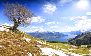 Panorama of meadows partially covered with snow with Lake Como on the background, Montemezzo, Alpe Zocca, Lombardy, Italian Lakes, Italy, Europe