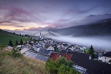 Pink clouds and mist on the village of Ardez at dawn, district of Inn, Lower Engadine, Canton of Graubunden, Switzerland, Europe