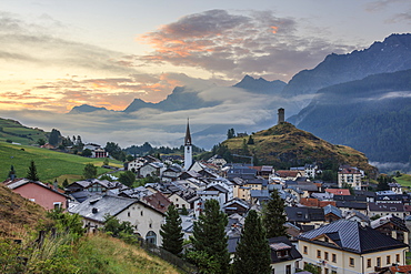 Misty sky on the alpine village of Ardez at sunrise, district of Inn, Lower Engadine, Canton of Graubunden, Switzerland, Europe