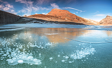 Panoramic of frozen lake Montespluga at dawn, Chiavenna Valley, Sondrio province, Valtellina, Lombardy, Italy, Europe