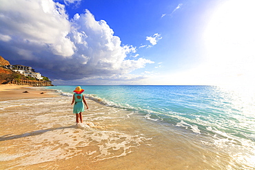 Rear view of woman with hat walking on Ffryes Beach, Antigua, Antigua and Barbuda, Leeward Islands, West Indies, Caribbean, Central America