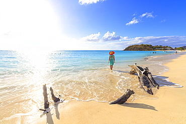 Rear view of woman with hat walking on Ffryes Beach, Antigua, Antigua and Barbuda, Leeward Islands, West Indies, Caribbean, Central America