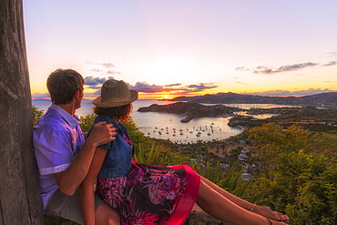 Couple look across English Harbour from Shirley Heights at sunset, Antigua, Antigua and Barbuda, Leeward Islands, West Indies, Caribbean, Central America