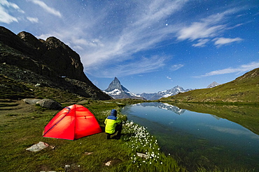 Hiker beside tent looking towards the Matterhorn from lake Riffelsee, Zermatt, canton of Valais, Swiss Alps, Switzerland, Europe