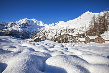 Huts in the snow with Monte Disgrazia on background, Alpe dell'Oro, Valmalenco, Valtellina, Sondrio province, Lombardy, Italy, Europe