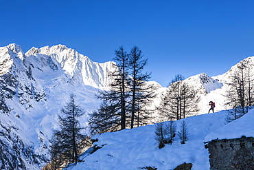 Photographer at the foot of snowy Monte Vazzeda, Alpe dell'Oro, Valmalenco, Valtellina, Sondrio province, Lombardy, Italy, Europe