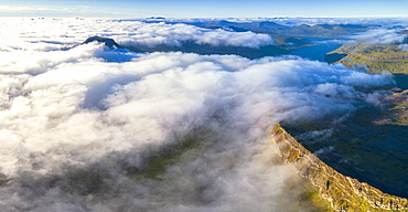 Aerial panoramic of clouds on the rocky peaks of Skaelingsfjall and Sornfelli mountains, Streymoy island, Faroe Islands, Denmark, Europe