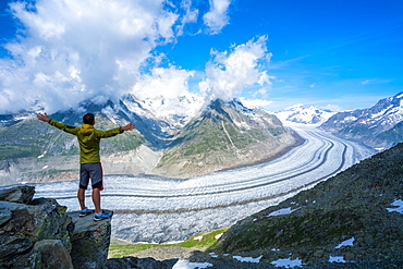 Man exulting with outstretched arms looking at Aletsch Glacier from Eggishorn viewpoint, Bernese Alps, canton of Valais, Switzerland, Europe