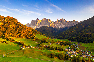 Sunset on the little village of Santa Magdalena and Odle peaks in autumn, aerial view, Funes, Dolomites, South Tyrol, Italy, Europe