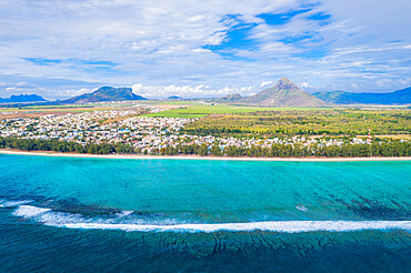 Aerial view by drone of waves crashing on Flic en Flac beach with Piton de la Petite Riviere Noire mountain, Mauritius, Indian Ocean, Africa