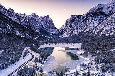 Sunrise over the icy Lake Dobbiaco and woods in winter, Dobbiaco, Val Pusteria, Dolomites, Bolzano province, South Tyrol, Italy, Europe