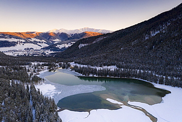 Sunrise over the village of Dobbiaco and frozen lake, Val Pusteria, Dolomites, Bolzano province, South Tyrol, Italy, Europe