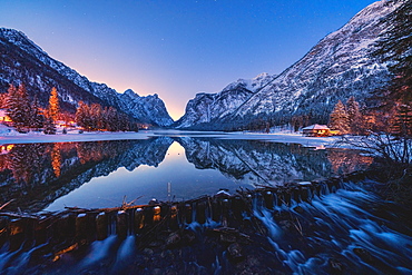 Dusk lights on the snowy peaks mirrored in Lake Dobbiaco, Val Pusteria, Dolomites, Bolzano province, South Tyrol, Italy, Europe