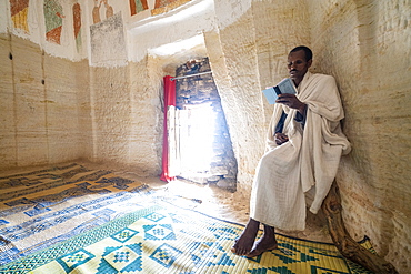 Priest holding the prayer book in the Orthodox Christian Daniel Korkor church, Gheralta Mountains, Tigray Region, Ethiopia, Africa