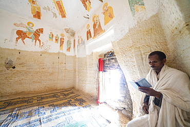 Priest holding the prayer book in the Orthodox Christian Daniel Korkor church, Gheralta Mountains, Tigray Region, Ethiopia, Africa