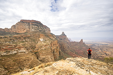 Male hiker admiring Gheralta Mountains canyons from top of rocks, Tigray Region, Ethiopia, Africa