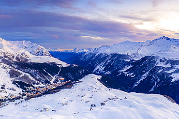 Aerial view by drone of sunset on the snowy peaks surrounding Madesimo and Andossi, Valchiavenna, Valtellina, Lombardy, Italy, Europe