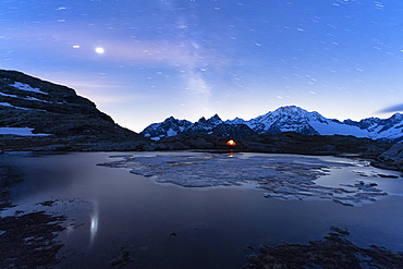 Tent under starry sky and Milky Way with Monte Disgrazia in background, Alpe Fora, Valmalenco, Sondrio province, Lombardy, Italy, Europe