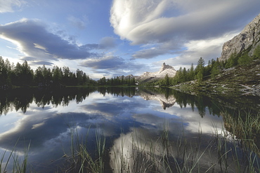 Clouds at sunrise over Rifugio Croda da Lago and Becco di Mezzodi reflected in Lake Federa, Ampezzo Dolomites, Veneto, Italy, Europe