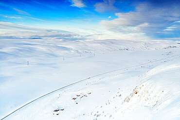 Aerial view of empty road crossing mountains covered with deep snow after blizzard, Sennalandet, Alta, Troms og Finnmark, Arctic, Norway, Scandinavia, Europe