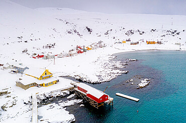 Fishing village of Sorvaer framed by the cold sea during a snowy winter, Soroya Island, Hasvik, Troms og Finnmark, Arctic, Norway, Scandinavia, Europe