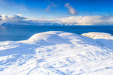 Aerial view of white mountains covered with snow surrounding the blue frozen sea, Hasvik, Soroya Island, Troms og Finnmark, Arctic, Norway, Scandinavia, Europe