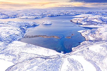 Aerial view of Norwegian County Road 98 along snowy mountains above Laksefjorden, Lebesby, Kunes, Troms og Finnmark, Arctic, Norway, Scandinavia, Europe