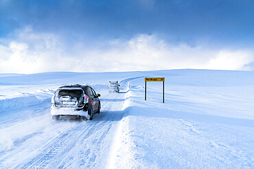 Off road vehicles driving on the icy road towards Nordkapp (North Cape) in the deep snow, Troms og Finnmark, Northern Norway, Scandinavia, Europe